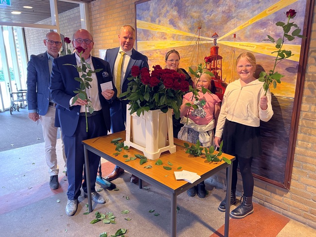 kinderen delen rozen uit aan vrijwilligers HGL