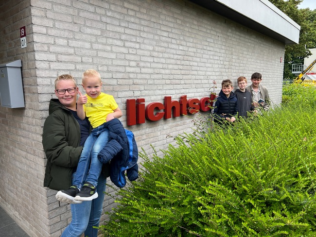 big smile kinderen bij naambord 't Lichtschip na kerkdienst HGL